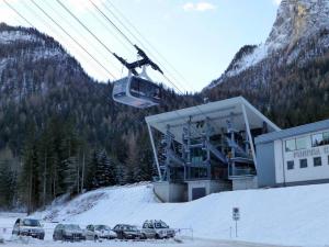 ein Skilift mit im Schnee geparkten Autos in der Unterkunft Chalet La Viola in Alba di Canazei + 13 Fotos