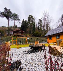 un cortile con buca per il fuoco e una casa di Srebrna Polana - sauna, jacuzzi a Międzybrodzie Bialskie Altre 26 foto