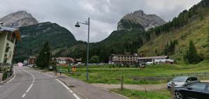 eine Straßenlaterne am Straßenrand mit Bergen in der Unterkunft Chalet La Viola in Alba di Canazei