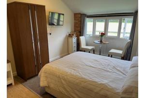 una camera da letto con un letto, un tavolo e delle sedie di Halfway Inn a Morden