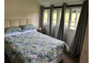 una camera da letto con un letto con copriletto floreale di Halfway Inn a Morden Altre 5 foto