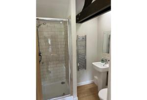 ein Badezimmer mit Dusche, Toilette und Waschbecken in der Unterkunft Halfway Inn in Morden