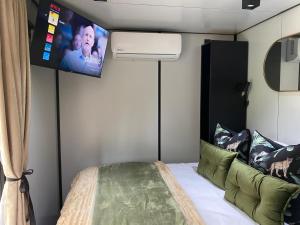 a bedroom with a bed with a tv on the wall at Stacey's Mini Hideaway in Hillcrest