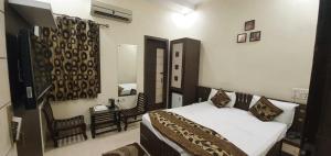 a bedroom with a bed and a chair in it at Hotel Sunshine in Bathinda