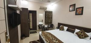 a bedroom with a bed and a room with a desk at Hotel Sunshine in Bathinda