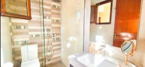a bathroom with a sink and a shower with a mirror at Knossos Skynest in Palekastron +7 photos