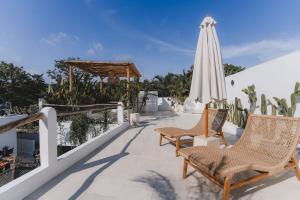 a patio with chairs and an umbrella and a umbrella at Private 1 bedroom villa with rooftop and pool in Tumbak Bayuh