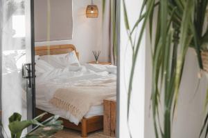a bedroom with a bed with white sheets and a mirror at Private 1 bedroom villa with rooftop and pool in Tumbak Bayuh +61 photos