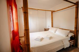 ein Schlafzimmer mit einem Himmelbett und Handtüchern darauf in der Unterkunft Silversol in Jávea + 20 Fotos