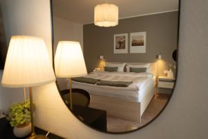 a bedroom with a bed with two lamps and a mirror at The Resting Place in Lemgo