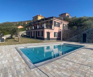 a house with a swimming pool in front of a house at Villa swimming pool Ca'Du'Ma' Portofino view ovest in Lavagna
