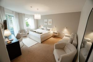 a bedroom with a bed and a couch and chairs at The Resting Place in Lemgo