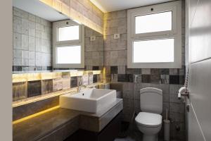 a bathroom with a sink and a toilet and two windows at New Giza Boho Bliss in Abū Rawwāsh +18 photos