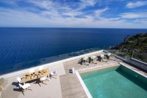 een luchtzicht op een zwembad en de oceaan bij Villa Ilenia in Skála Kefalonias