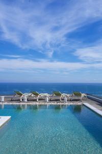 een zwembad met stoelen en de oceaan op de achtergrond bij Villa Ilenia in Skála Kefalonias