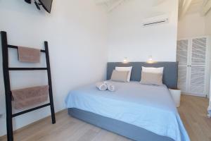 een slaapkamer met een bed met blauwe lakens en een ladder bij Villa Ilenia in Skála Kefalonias +32 foto's