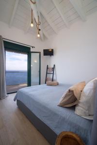 een slaapkamer met een bed met uitzicht op de oceaan bij Villa Ilenia in Skála Kefalonias