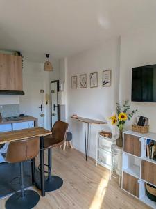 ein Wohnzimmer mit Tisch und Küche in der Unterkunft Le Colibri - studio paisible et raffiné au sud d'Aix in Aix-en-Provence