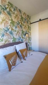 ein Bett mit weißen Laken und Kissen in einem Schlafzimmer in der Unterkunft Le Colibri - studio paisible et raffiné au sud d'Aix in Aix-en-Provence