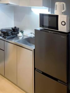 a microwave sitting on top of a stove in a kitchen at カレラ豊平2nd in Sapporo
