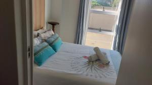 a bed with a stuffed animal laying on it at Ballito Floridian in Ballito +21 photos