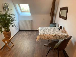 a room with a table and chairs and a plant at B&B L'Atout de France in Fléré-la-Rivière