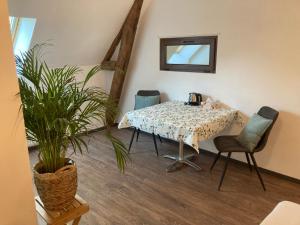 a room with a table and chairs and a plant at B&B L'Atout de France in Fléré-la-Rivière