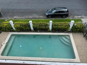 a car parked next to a small swimming pool at Palmview Escape in Yorkeys Knob