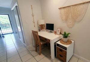 a desk with a computer and a chair in a room at Palmview Escape in Yorkeys Knob