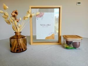 a vase with flowers in it next to a picture at Au nid du colibri in Somme-Leuze +2 photos