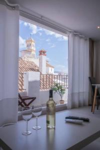 Una botella de vino sobre una mesa con dos copas. en Tetuan Boutique Apartment in Old Town Marbella, en Marbella