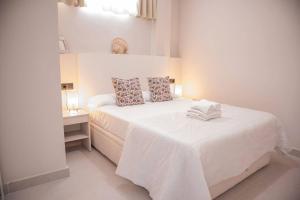 Un dormitorio blanco con una gran cama blanca y una mesa. en Tetuan Boutique Apartment in Old Town Marbella, en Marbella