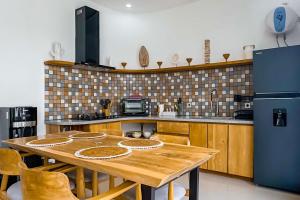 a kitchen with a wooden table and a refrigerator at Luxurious Semeniyak new 2BR villa with a pool in Seminyak