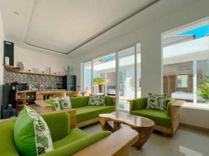 a living room with green couches and a table at Luxurious Semeniyak new 2BR villa with a pool in Seminyak