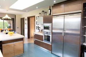 cocina con nevera grande de acero inoxidable en La Cantera Rural Spa, en Viñaixa