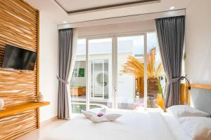 a bedroom with a white bed with a large window at Luxurious Semeniyak new 2BR villa with a pool in Seminyak