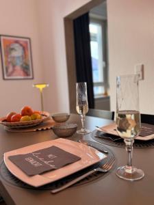 a table with two glasses of wine on top of it at StaySimplyHaven - Modernes City-Apartment, King-Size Bett, 55'' Smart-TV, Self Check-In in Braunschweig +21 photos