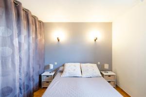 una piccola camera con un letto e due comodini di Appartement Txikia ad Amotz