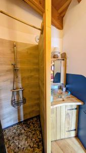 a bathroom with a wooden wall with a sink at Fount de Cousteno in Limbrassac