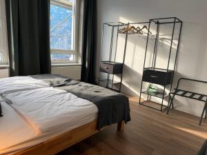 a bedroom with a bed and a window and a chair at StaySimplyHaven - Modernes City-Apartment, King-Size Bett, 55'' Smart-TV, Self Check-In in Braunschweig