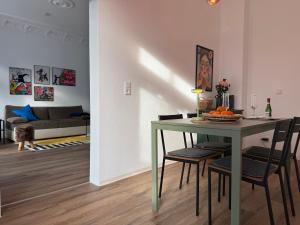 a living room with a table with chairs and a couch at StaySimplyHaven - Modernes City-Apartment, King-Size Bett, 55'' Smart-TV, Self Check-In in Braunschweig