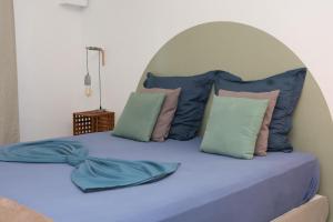 a large bed with blue sheets and pillows at Kaz Mboa Vista - Rémire-Montjoly in Montjoly