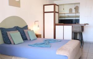 a blue bed with blue pillows in a room at Kaz Mboa Vista - Rémire-Montjoly in Montjoly