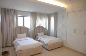 una camera da letto con due letti e una finestra di شقة في برج داماك a Gedda