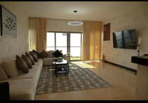 un soggiorno con un divano e un tavolo di شقة في برج داماك a Gedda