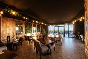 a restaurant with tables and chairs and windows at Springfield Hotel & Health Club in Halkyn