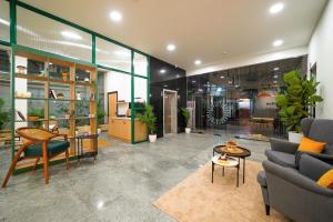 una sala de estar con un sofá y una mesa en Olive Hotel Hitec City by Embassy Group, en Hyderabad