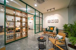 a living room with a green couch and some plants at Olive Hotel Hitec City by Embassy Group in Hyderabad