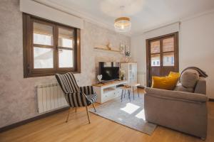 a living room with a couch and a television at Castillo Buenavista in Ponferrada
