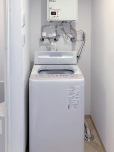a washer and dryer in a bathroom with a machine at カレラ豊平2nd in Sapporo